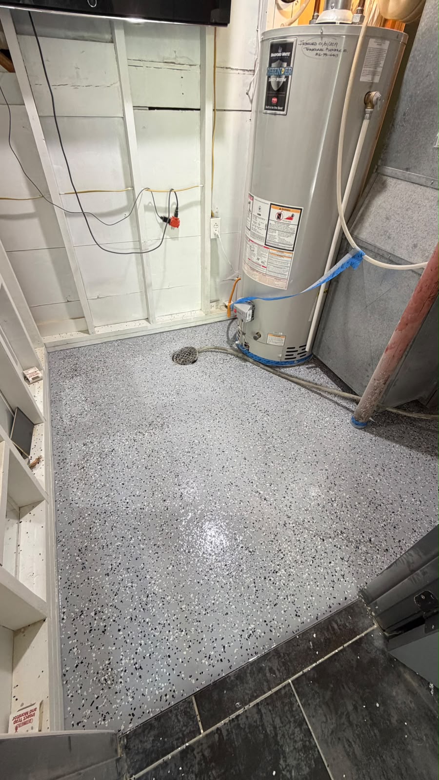 Interior utility space with a speckled floor coating around existing equipment